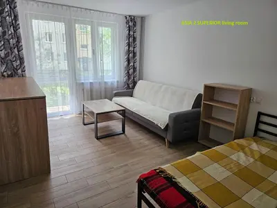 a living room with a couch and a bed at Apartamenty Asia Kraków in Kraków