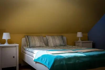 a bed in a room with two night stands and two lamps at Spacious house in the rural suburbs of Krakow in Zagacie