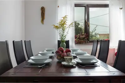 a dining room table with bowls and plates and a bowl of fruit at Spacious house in the rural suburbs of Krakow in Zagacie