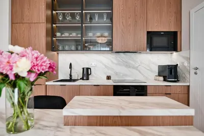 a kitchen with a table and a vase of pink flowers at Jasmine Grand 7 by Housine in Zator