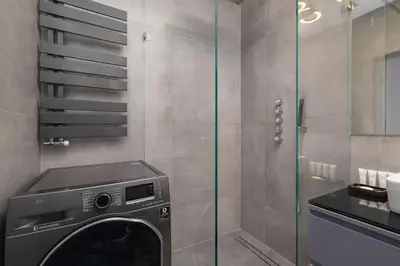 a bathroom with a washing machine in a shower at Żabiniec Stylish Apartment in Cracow with Balcony by Noclegi Renters in Kraków