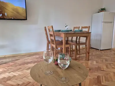 a kitchen with a table and two wine glasses at Dąbie Park Apartament in Kraków
