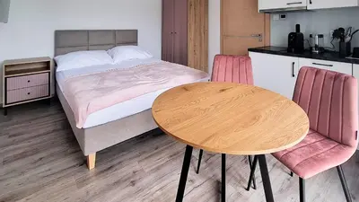 a bedroom with a bed and a table and chairs at Apartamenty w sadzie in Przenosza
