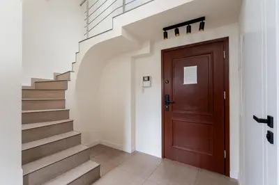 a hallway with a wooden door and stairs at Tomasza 20 Apartment in Kraków