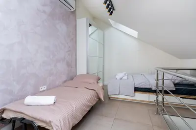 two beds in a small room with a staircase at Tomasza 20 Apartment in Kraków