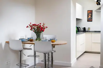 a kitchen with a table with a vase of flowers on it at Tomasza 20 Apartment in Kraków