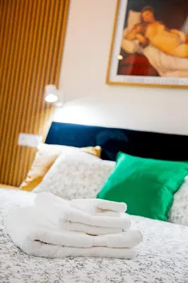 a pile of white towels sitting on top of a bed at PAUL-IN-SKY Apartment Krakow in Kraków