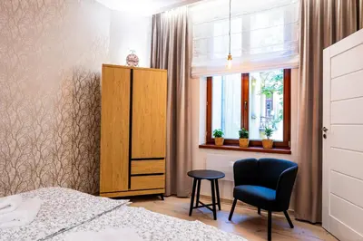 a bedroom with a bed and a chair and a window at PAUL-IN-SKY Apartment Krakow in Kraków