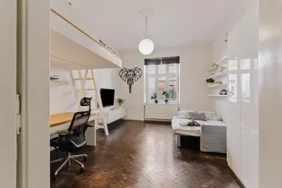 a living room with a bed and a desk in a room at Traugutta Loft in Kraków