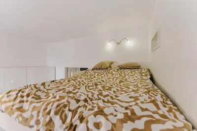a bed in a white room with a tiger print bedspread at Traugutta Loft in Kraków