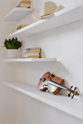 a violin is sitting on a white shelf at Traugutta Loft in Kraków