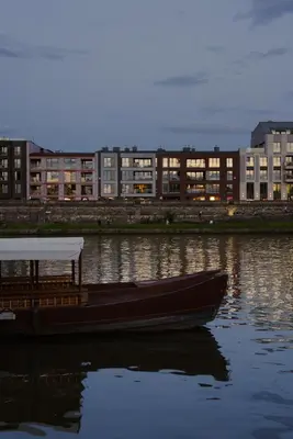 a boat in the water with buildings in the background at Traugutta Loft in Kraków
