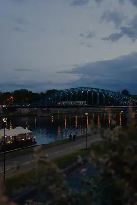 a bridge over a body of water at night at Traugutta Loft in Kraków