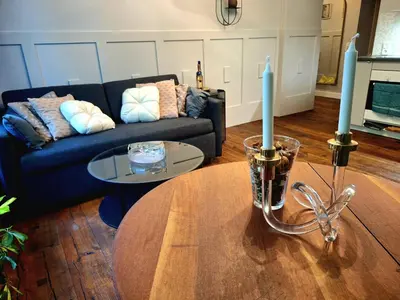 a living room with a couch and a table with a candle at Comfy Corners in Kraków