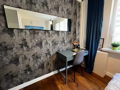 a room with a desk and a mirror on a wall at Comfy Corners in Kraków
