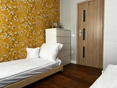 a bedroom with a bed and a yellow wall at Comfy Corners in Kraków