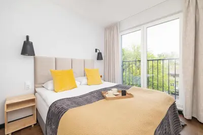 a bedroom with a bed with yellow pillows and a window at Modern & Luxurious Apartment with Balcony & Parking Cracow by Renters Prestige in Kraków