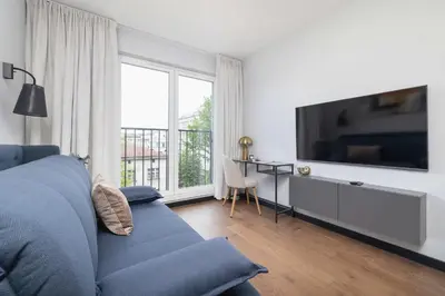 a living room with a blue couch and a tv at Modern & Luxurious Apartment with Balcony & Parking Cracow by Renters Prestige in Kraków
