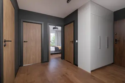 an empty hallway with wooden doors and a bedroom at Modern & Luxurious Apartment with Balcony & Parking Cracow by Renters Prestige in Kraków