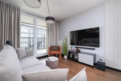 a living room with a couch and a flat screen tv at Modern & Luxurious Apartment with Balcony & Parking Cracow by Renters Prestige in Kraków