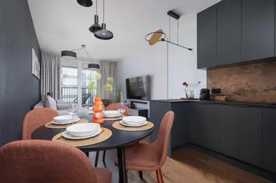 a dining room with a table and chairs in a kitchen at Modern & Luxurious Apartment with Balcony & Parking Cracow by Renters Prestige in Kraków