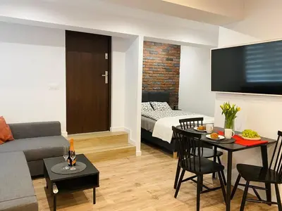 a living room with a couch a table and a bed at Rzeszowska 5 Apt 02 in Kraków