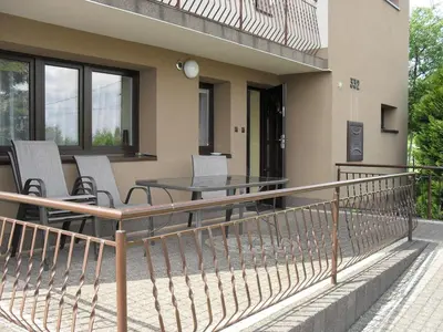 a balcony of a house with a table and chairs at Noclegi u Zosi in Staniątki