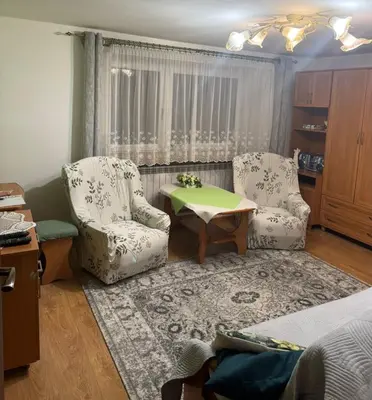 a living room with two chairs and a table at Noclegi u Zosi in Staniątki