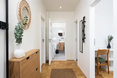 a hallway with a mirror and a table and a chair at Kazimierz Hideaway by Upstairs in Kraków