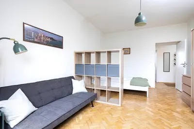 a living room with a couch and a bedroom at Kazimierz Hideaway by Upstairs in Kraków