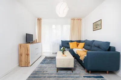 a living room with a blue couch and a table at Quiet Quarter - by Upstairs in Kraków