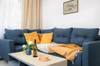 a blue couch with orange pillows and a table at Quiet Quarter - by Upstairs in Kraków