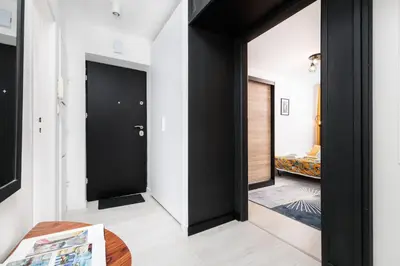 a hallway with black doors and a room with a bed at Quiet Quarter - by Upstairs in Kraków