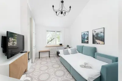 a living room with a couch and a tv at Zakopiańska 2B Homely Apartment by BookingHost in Kraków