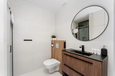 a bathroom with a sink and a mirror at Zakopiańska 2B Homely Apartment by BookingHost in Kraków