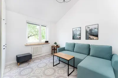 a living room with a blue couch and a table at Zakopiańska 2B Homely Apartment by BookingHost in Kraków