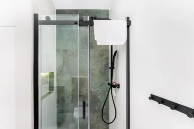 a shower with a glass door in a bathroom at Zakopiańska 2B Homely Apartment by BookingHost in Kraków