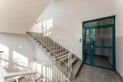 a staircase with a blue door in a building at Zakopiańska 2B Homely Apartment by BookingHost in Kraków