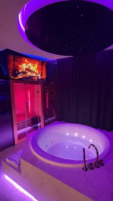 a large bath tub in a room with a fireplace at Jacuzzi Glass-House Rakowicka 20 Central Station in Kraków