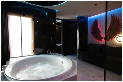 a bathroom with a large tub with a peacock painting on the wall at Jacuzzi Glass-House Rakowicka 20 Central Station in Kraków