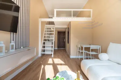 a living room with a couch and a stair case at Apartament z Antresolą i Prywatnym Patio in Kraków
