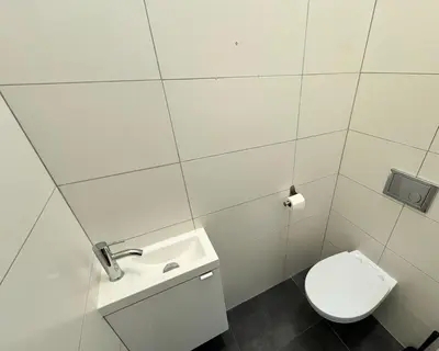 a white bathroom with a toilet and a sink at Fantastic-Inn Kraków - GR6 in Kraków