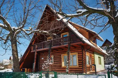 a log cabin with snow on the roof at Drewniany Dom Rabka Zdrój in Rabka