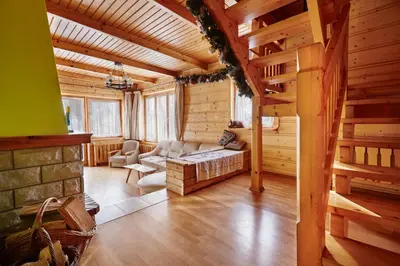 a living room with a couch and stairs in a cabin at Drewniany Dom Rabka Zdrój in Rabka