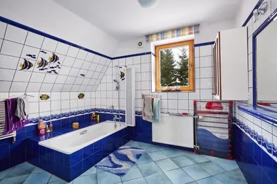 a blue and white bathroom with a tub and a window at Drewniany Dom Rabka Zdrój in Rabka