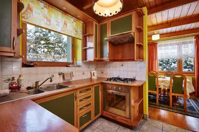 a kitchen with a sink and a stove top oven at Drewniany Dom Rabka Zdrój in Rabka