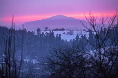 a mountain in the distance with a pink and purple sky at Drewniany Dom Rabka Zdrój in Rabka