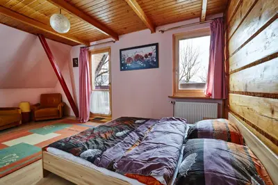 a bedroom with a bed in the corner of a room at Drewniany Dom Rabka Zdrój in Rabka