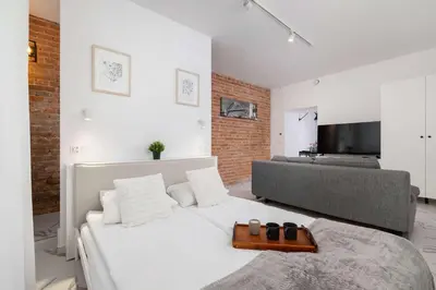 a bedroom with a white bed and a couch at Cozy Studios in the Old Town of Kraków by Noclegi Renters in Kraków