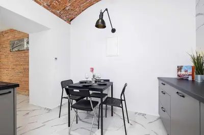 a dining room with a black table and chairs at Cozy Studios in the Old Town of Kraków by Noclegi Renters in Kraków